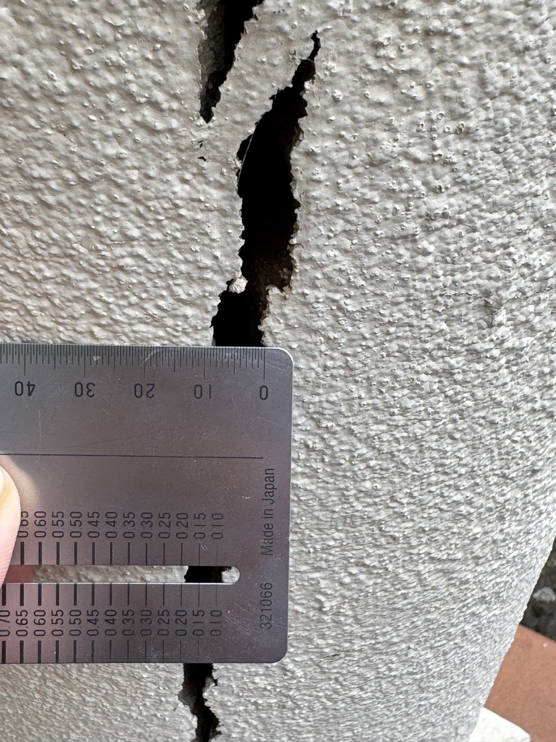 Measuring a wall crack with a ruler during a structural inspection in Melbourne